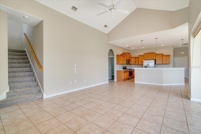 unfurnished living room featuring ceiling fan, high vaulted ceiling, and light tile patterned flooring