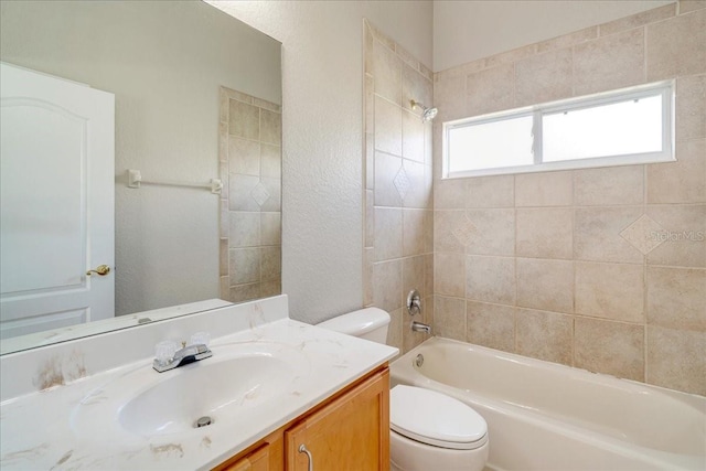 full bathroom with vanity, tiled shower / bath combo, and toilet