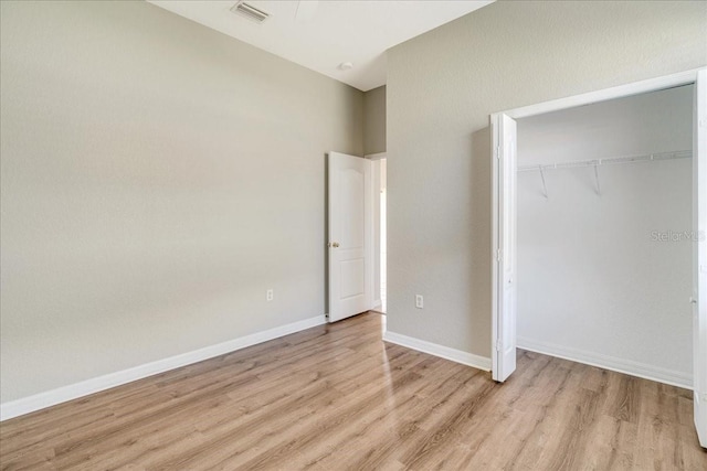 unfurnished bedroom with a closet and light wood-type flooring