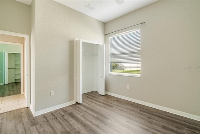 unfurnished bedroom with ceiling fan and light hardwood / wood-style flooring