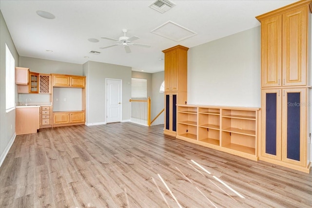 unfurnished living room featuring ceiling fan, sink, and light hardwood / wood-style flooring