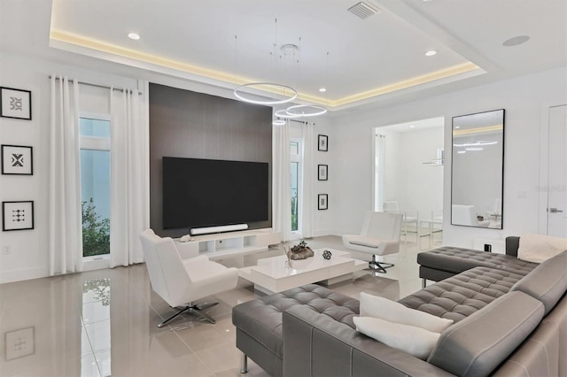 tiled living room featuring a tray ceiling