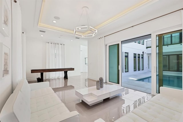 living room with light tile patterned floors and a raised ceiling