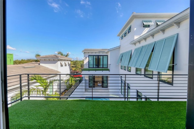 exterior space featuring a balcony and a lawn