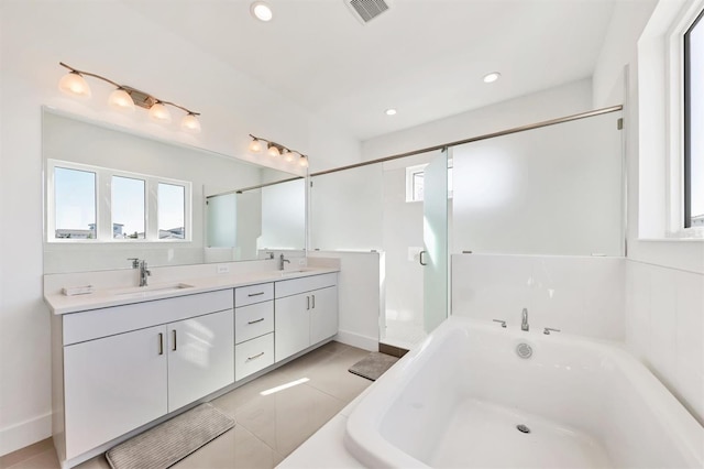 bathroom with tile patterned flooring, vanity, and a bath