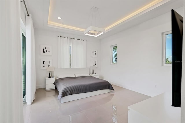 bedroom featuring light tile patterned floors and a tray ceiling