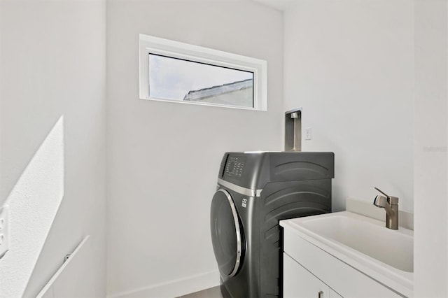 laundry room with cabinets, sink, and washer / clothes dryer