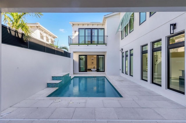 rear view of house featuring a patio area and a balcony