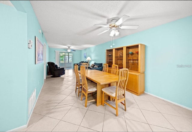 dining room with ceiling fan, light tile patterned floors, and a textured ceiling