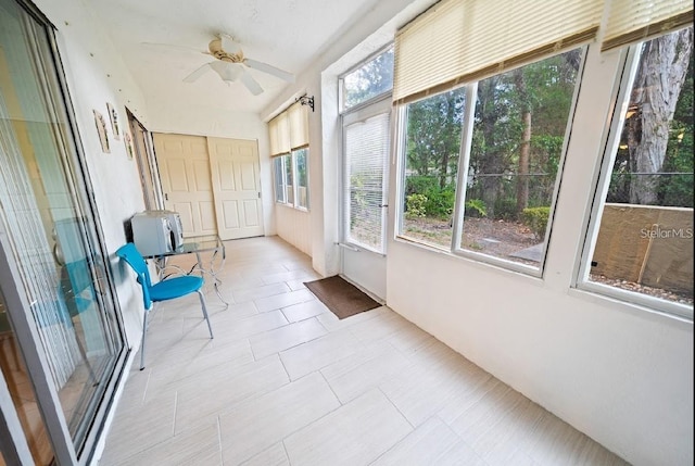 unfurnished sunroom with ceiling fan