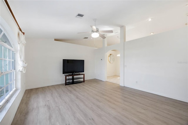 unfurnished living room with ceiling fan, vaulted ceiling, and light wood-type flooring