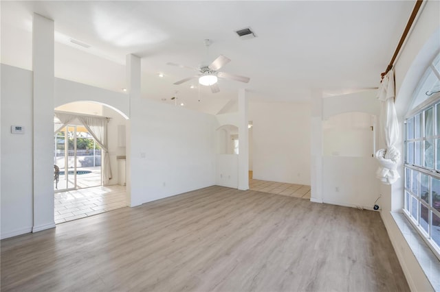 unfurnished living room featuring ceiling fan, high vaulted ceiling, and light wood-type flooring