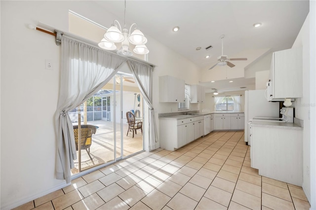 kitchen with white cabinetry, light tile patterned flooring, and ceiling fan with notable chandelier