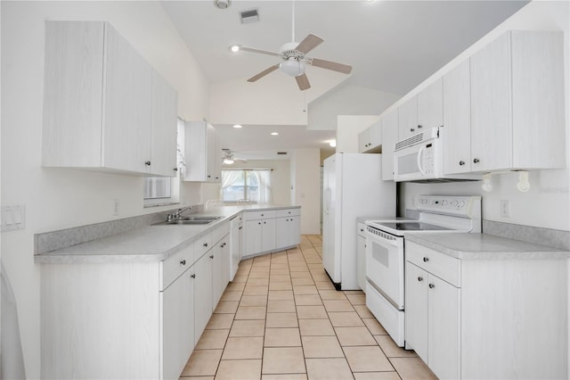 kitchen with sink, white appliances, white cabinets, light tile patterned flooring, and vaulted ceiling