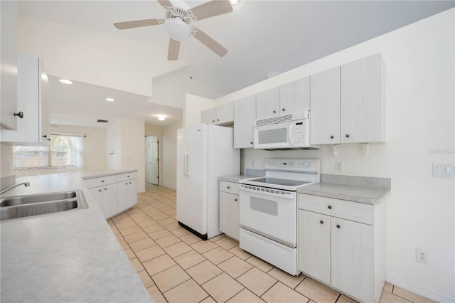 kitchen featuring lofted ceiling, sink, white cabinetry, light tile patterned floors, and white appliances