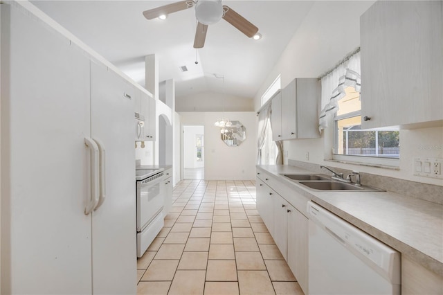 kitchen featuring light tile patterned flooring, white cabinetry, lofted ceiling, sink, and white appliances