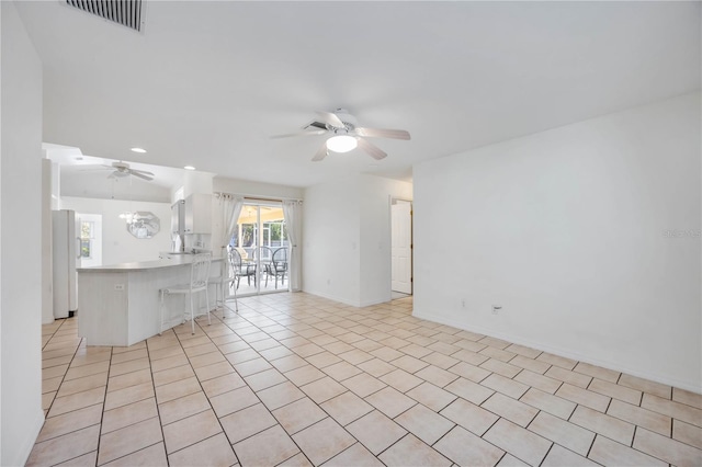 unfurnished living room featuring light tile patterned floors and ceiling fan