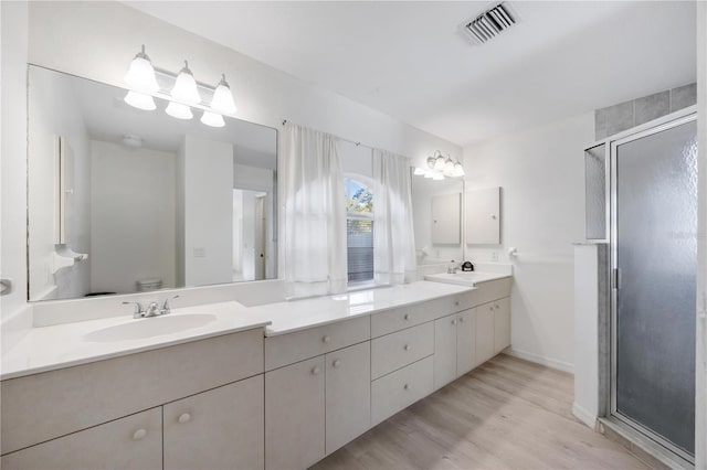 bathroom featuring hardwood / wood-style flooring, vanity, toilet, and an enclosed shower