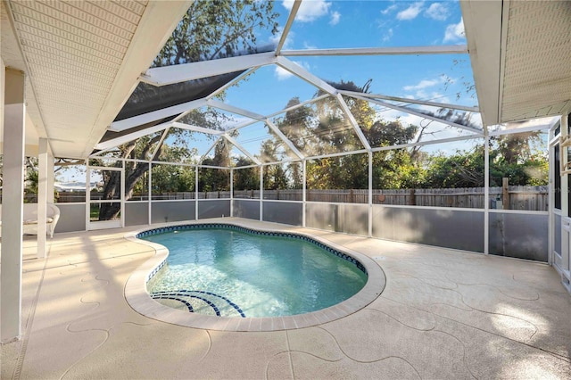 view of pool with a patio area and glass enclosure