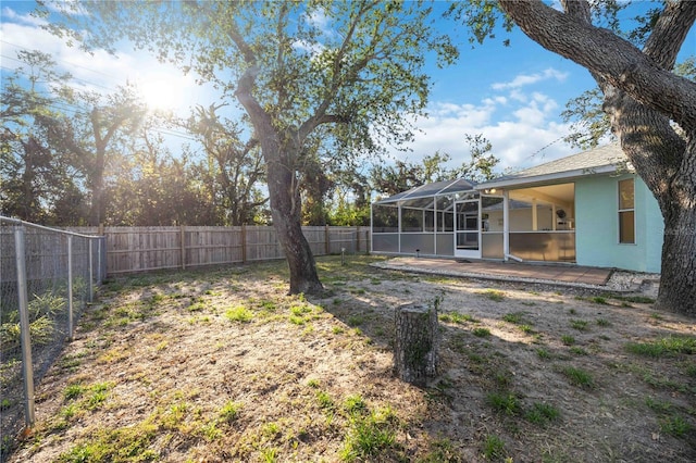 view of yard featuring a patio area and glass enclosure