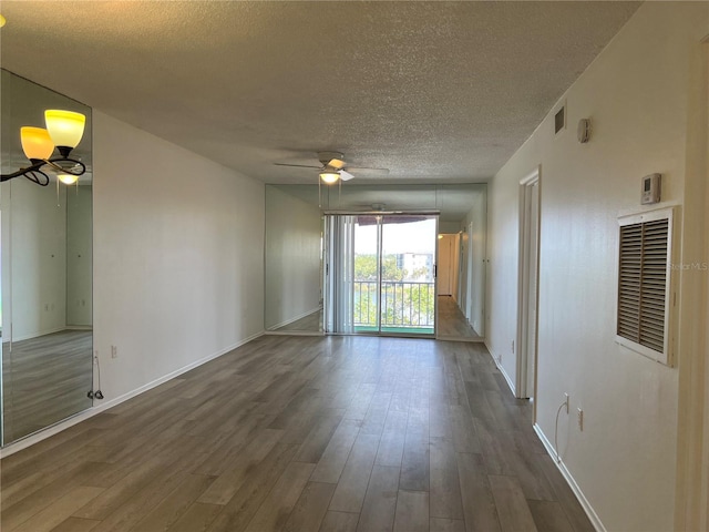 empty room featuring hardwood / wood-style floors, ceiling fan, and a textured ceiling