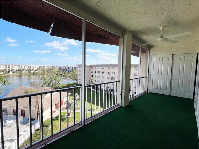 balcony with a water view and ceiling fan