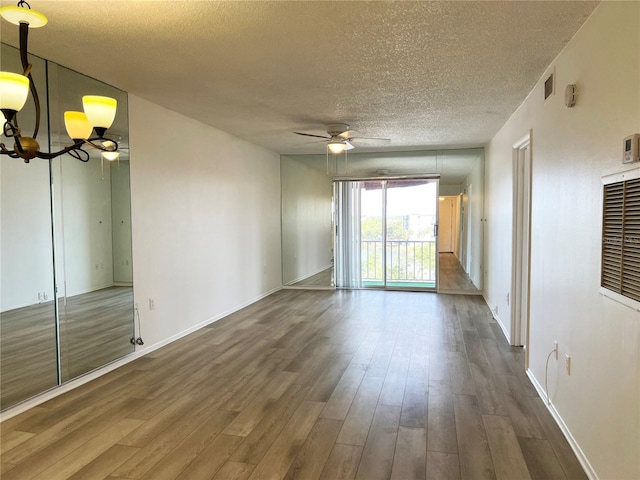 empty room with hardwood / wood-style floors, ceiling fan, and a textured ceiling