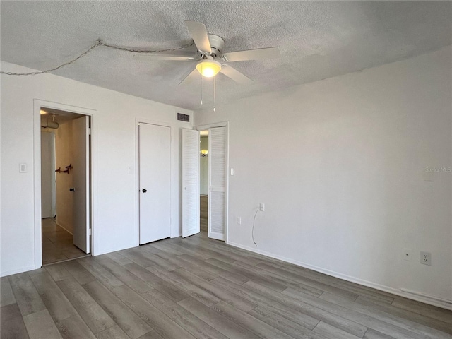 unfurnished bedroom with ceiling fan, a textured ceiling, and light hardwood / wood-style floors