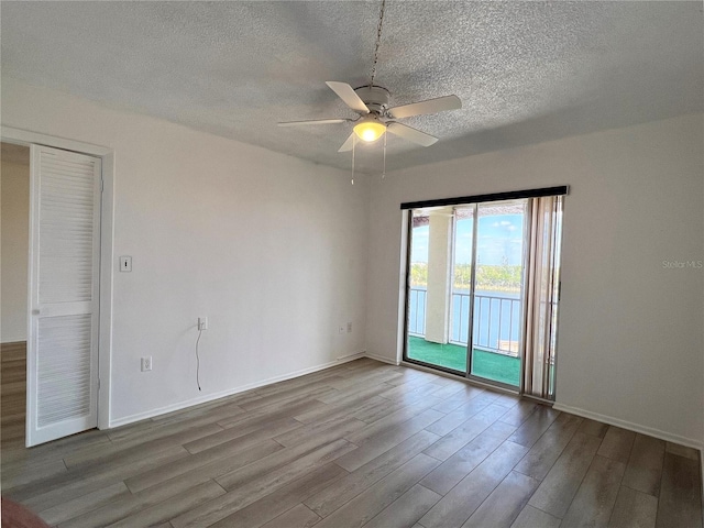 unfurnished room with ceiling fan, a textured ceiling, and light hardwood / wood-style flooring