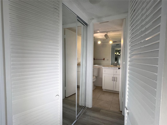 corridor featuring light hardwood / wood-style flooring and a textured ceiling