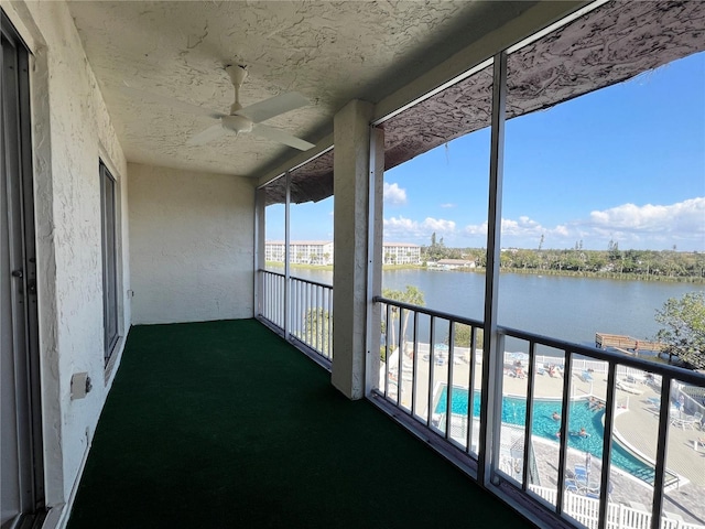 unfurnished sunroom featuring a water view and ceiling fan