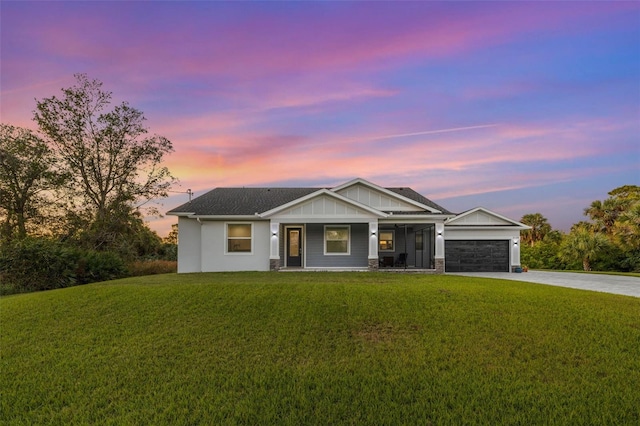 view of front of home featuring a porch, a garage, and a lawn