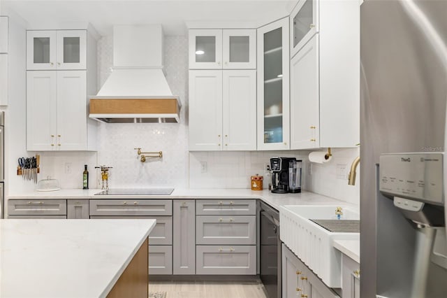 kitchen featuring decorative backsplash, premium range hood, gray cabinets, and water heater