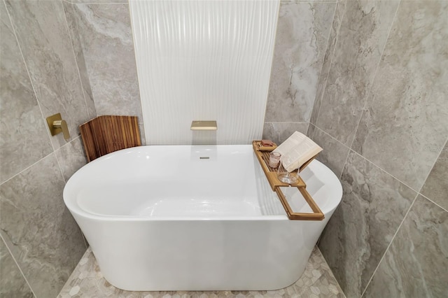 bathroom featuring a bathtub and tile walls