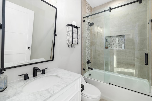 full bathroom featuring vanity, toilet, and shower / bath combination with glass door