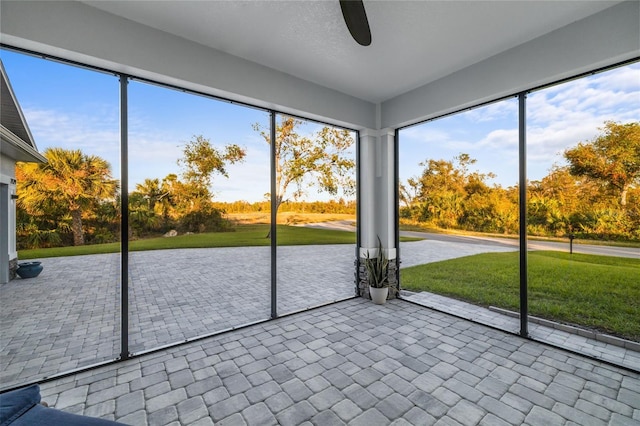 unfurnished sunroom with ceiling fan