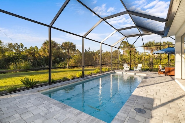 view of pool featuring a lawn, a patio area, and a lanai