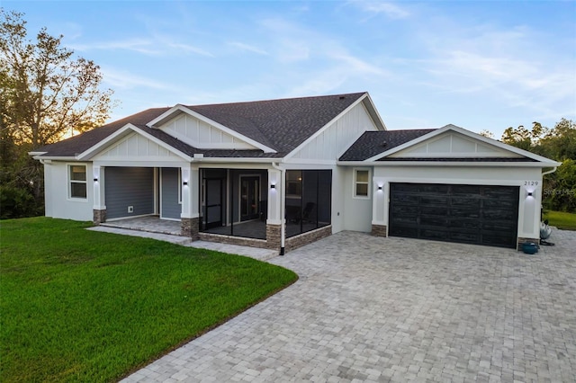 view of front of home with a sunroom, a garage, and a front yard