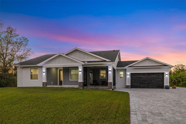 craftsman-style home with a porch, a garage, and a lawn