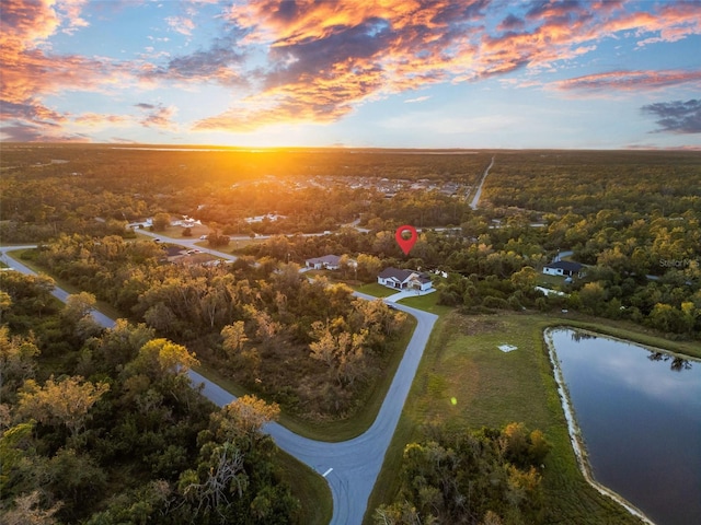 aerial view at dusk featuring a water view