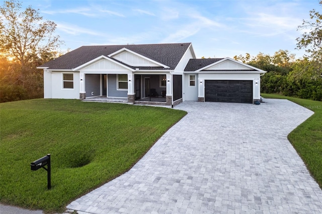 view of front of home with a front lawn, covered porch, and a garage