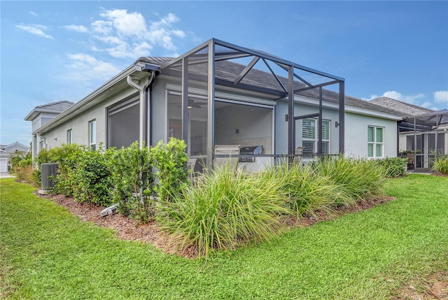 view of property exterior featuring glass enclosure, central AC unit, and a lawn