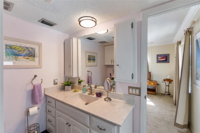 bathroom featuring vanity, ornamental molding, and a textured ceiling