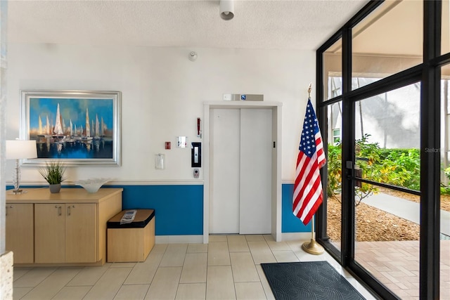 interior space featuring a textured ceiling and elevator