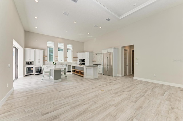 kitchen featuring a kitchen island, white cabinetry, stainless steel appliances, and light hardwood / wood-style flooring