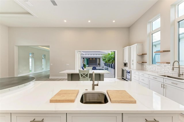 kitchen featuring a center island with sink, white cabinetry, and sink