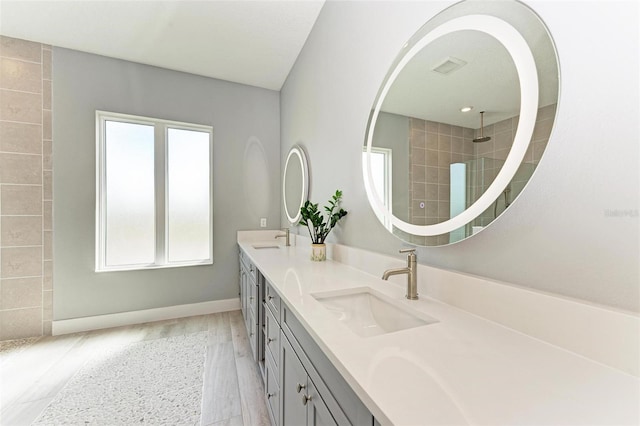 bathroom with walk in shower, hardwood / wood-style floors, vanity, and a wealth of natural light