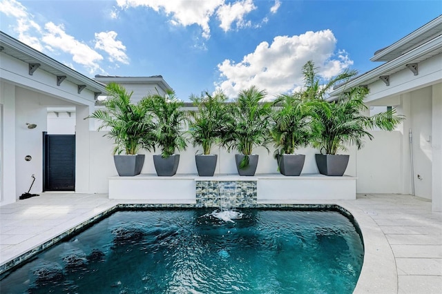 view of swimming pool featuring pool water feature and a patio