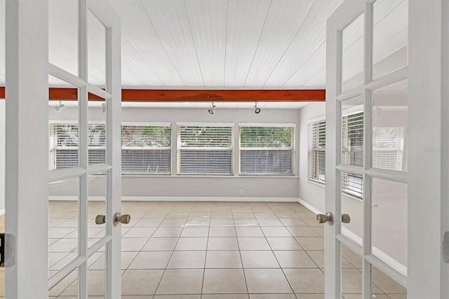 unfurnished sunroom with beam ceiling, french doors, and wood ceiling