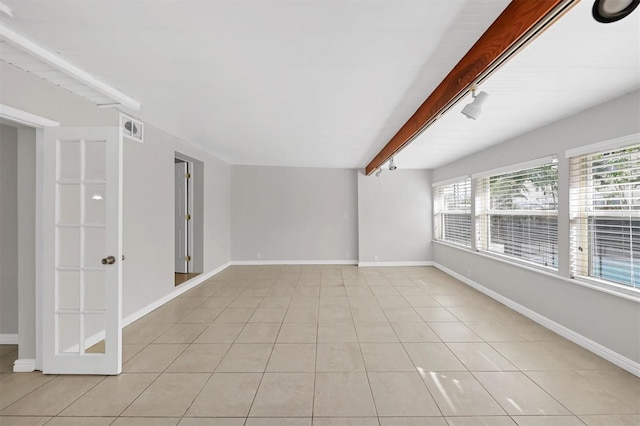 tiled spare room with beamed ceiling